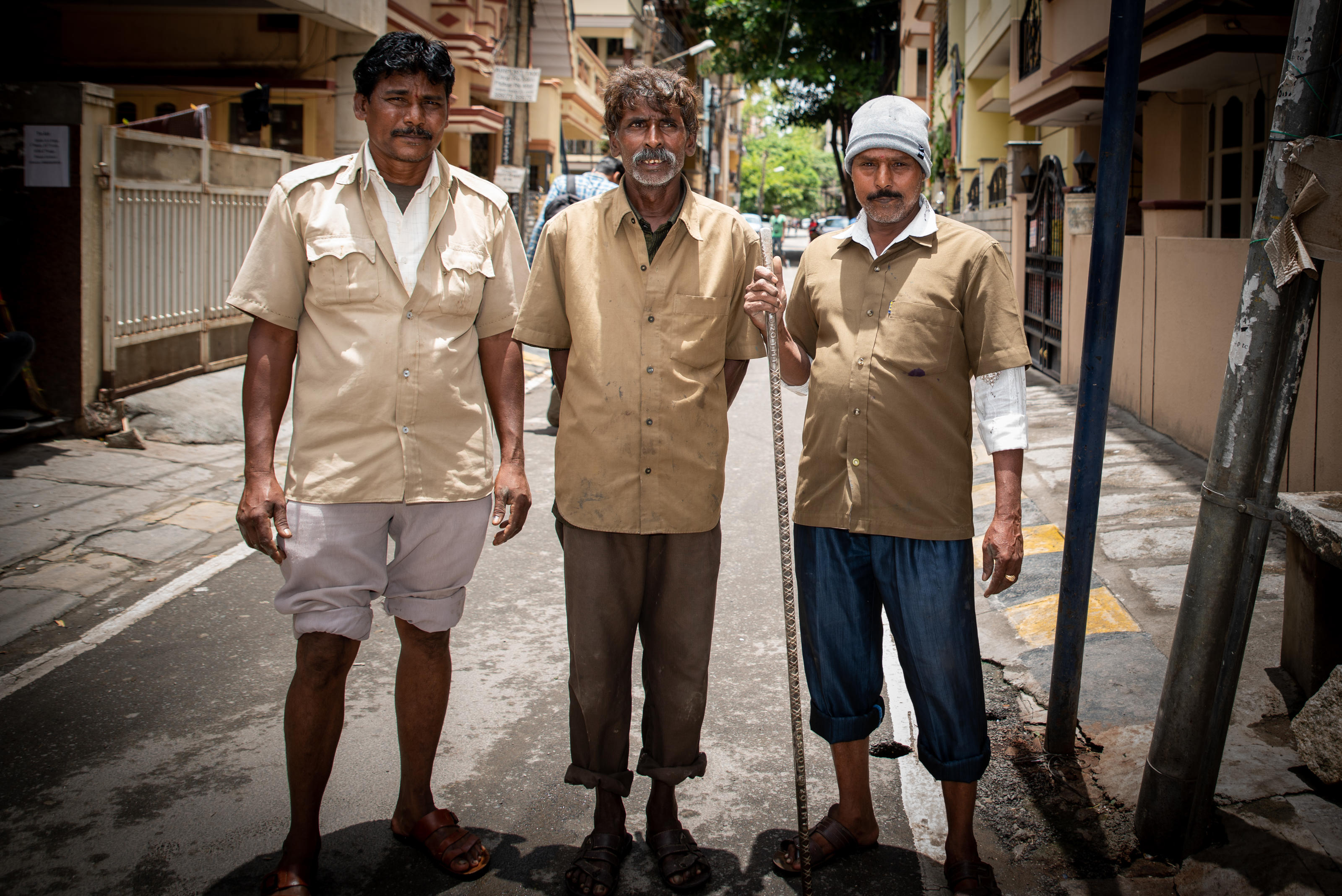 Gangalappa, 50 anos, (centro) é um funcionário do saneamento que faz a manutenção manual do esgoto para limpar bloqueios residenciais em Bangalore, Índia, entre dois amigos.