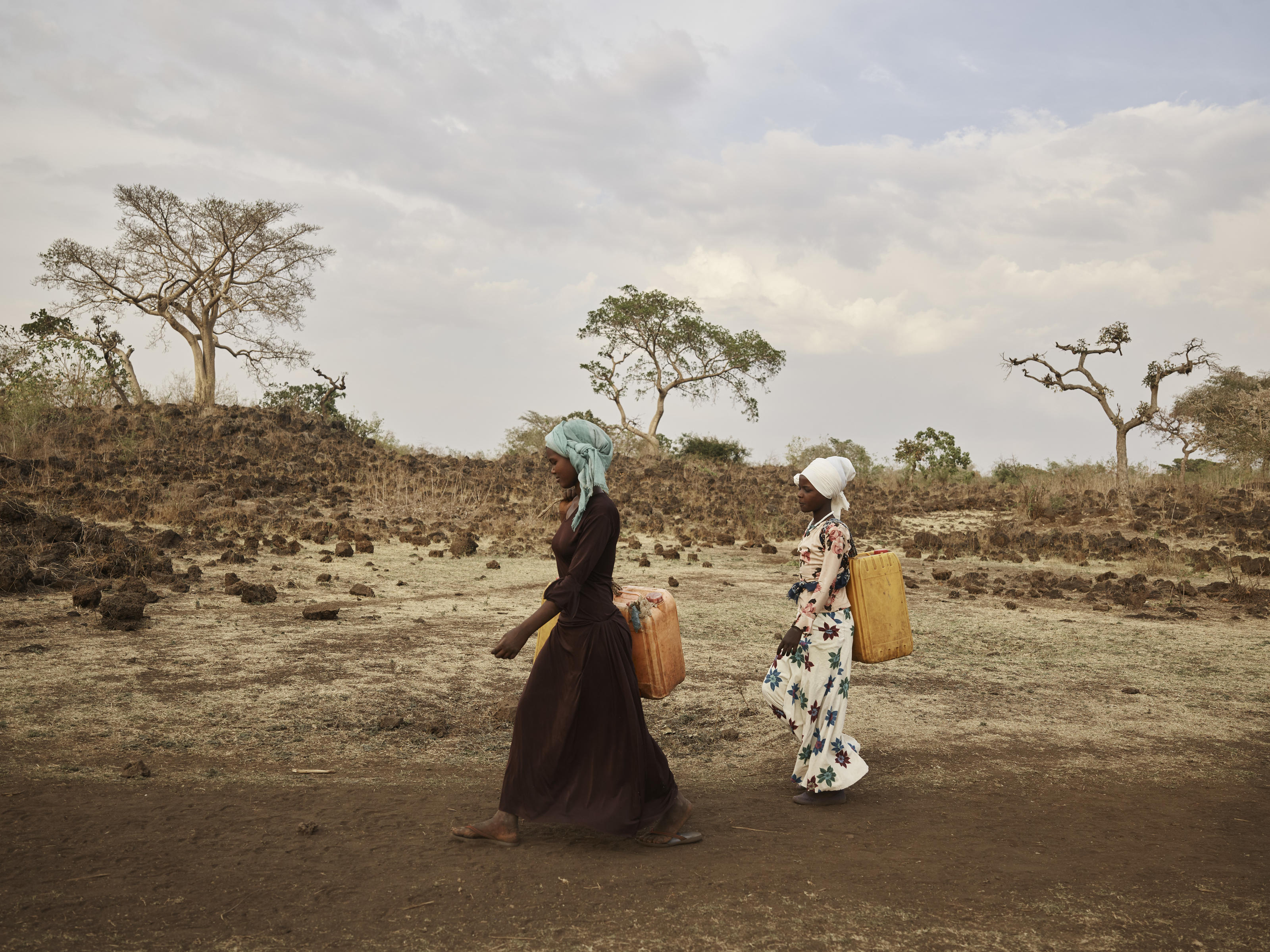 Kadija and her sister Ansha carry water from the River Lah in Ethiopia.
