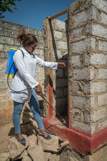 Sarah Chilima, técnico en salud ambiental, se prepara para desinfectar una letrina de pozo y prevenir la propagación del cólera en Lusaka, Zambia.