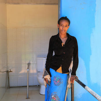 Tarfalech à frente das novas casas de banho para deficientes na Escola Básica Edget Bihibret, Amhara, Etiópia.